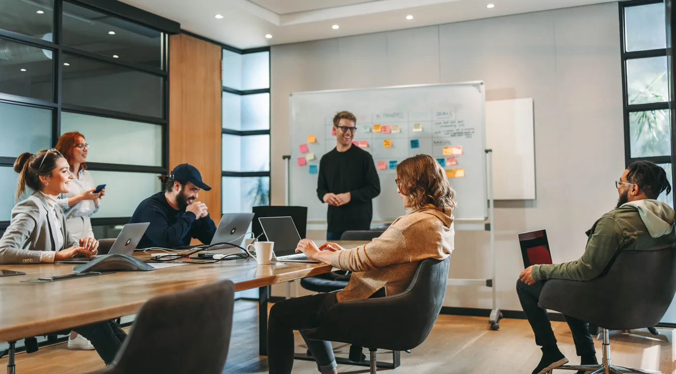 Collaborative creative agency team working around a large table in an open office.